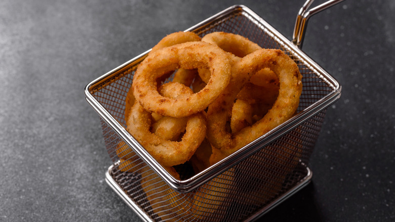 Breaded onion rings in a metal serving basket