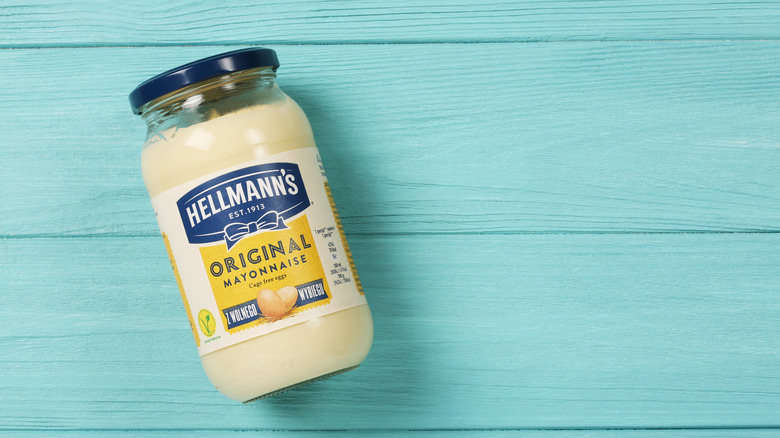 Jar of Hellman's mayonnaise on a blue wooden background
