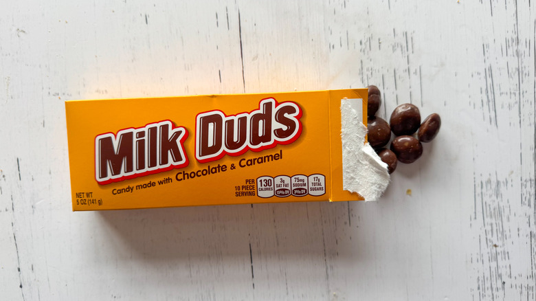 Milk Duds candy on white surface
