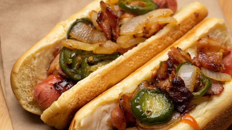 Hot dog with bacon and other toppings