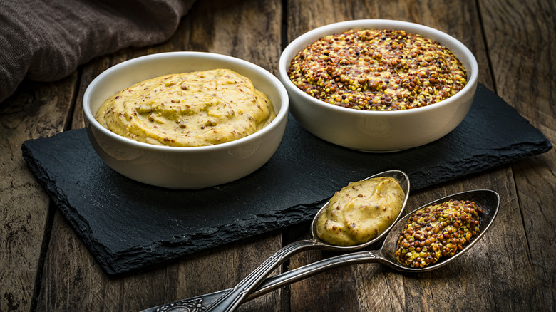 Spicy mustard in bowls with spoons
