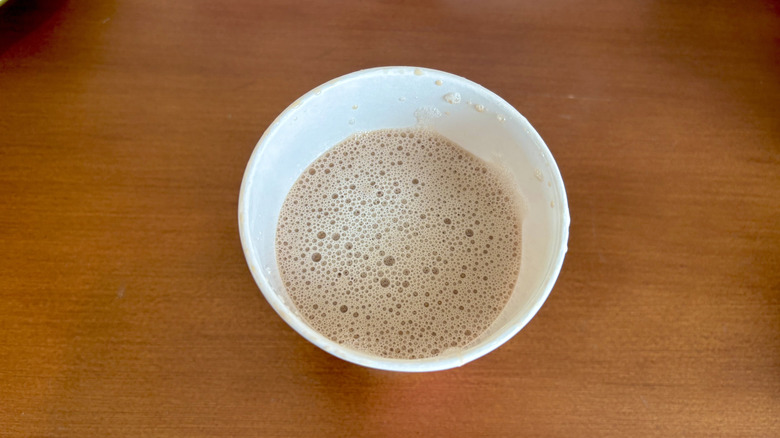 A chai latte from Dunkin' on a wood surface