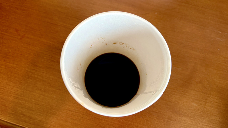 An espresso from Dunkin' on a wood surface