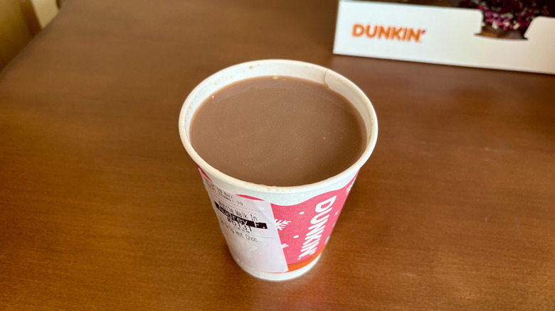 A hot chocolate from Dunkin' with a Dunkin' box in background