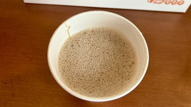 A latte from Dunkin' on a wood surface
