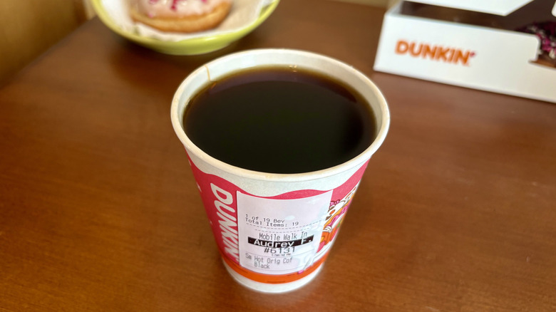 An Original Blend Coffee from Dunkin' with a Dunkin' box and donut in background