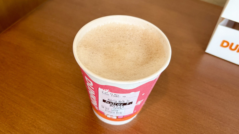 A Protein Latte from Dunkin' on a wooden table