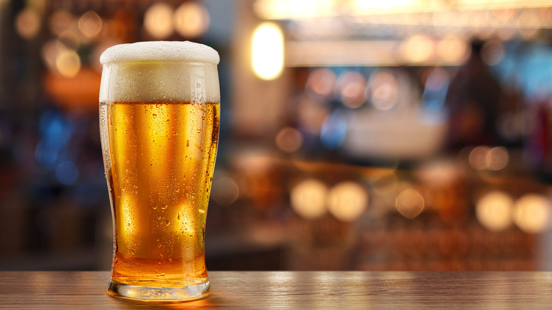 A glass of beer sits on a bar counter