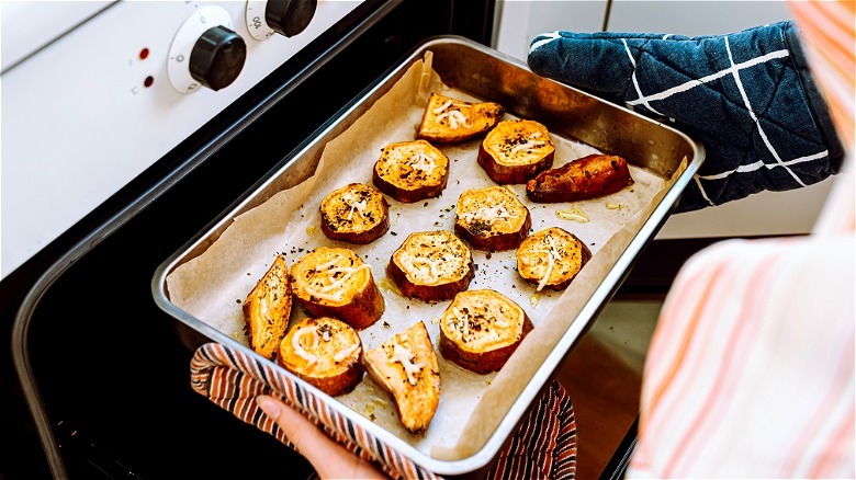 Sweet potatoes being removed from the oven