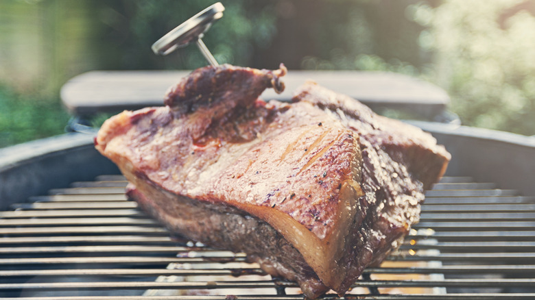 Brisket sizzles on a grill