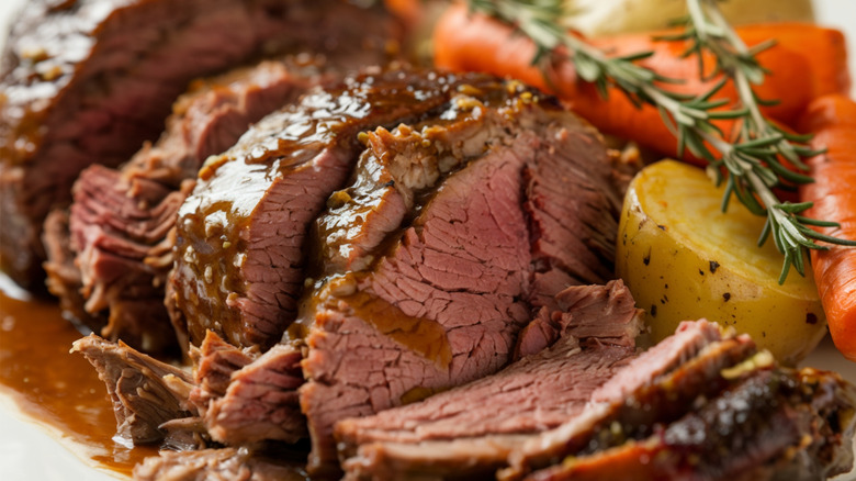 A tender, cooked pot roast with carrots and potatoes in gravy