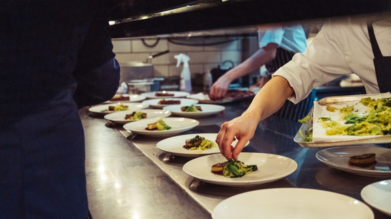 Fancy ingredients are plated in a restaurant kitchen.