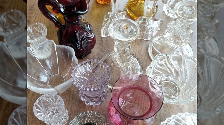 Assortment of vintage and antique glasswares on wood table.