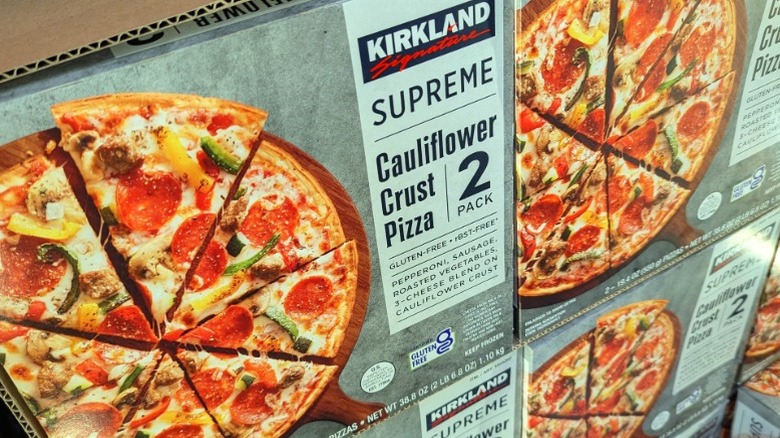 Boxes of Kirkland Signature Supreme Cauliflower Crust pizza for sale on a Costco freezer shelf.