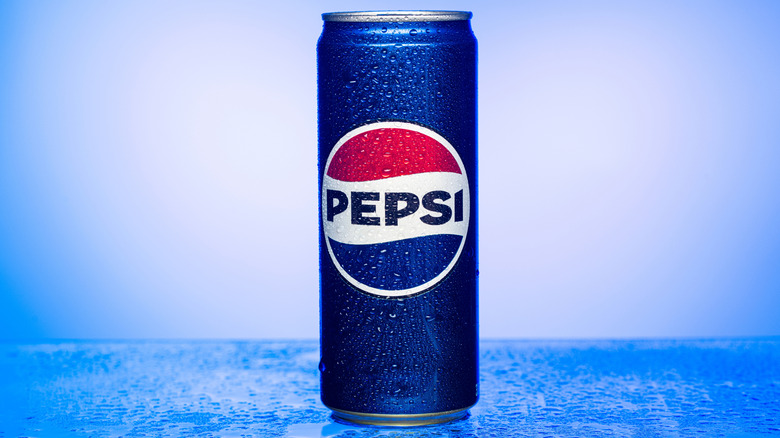 Close up of a frosty can of Pepsi on a light blue background and icy blue landscape