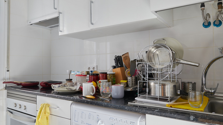 Cluttered kitchen counter filled with various glassware and kitchen tools