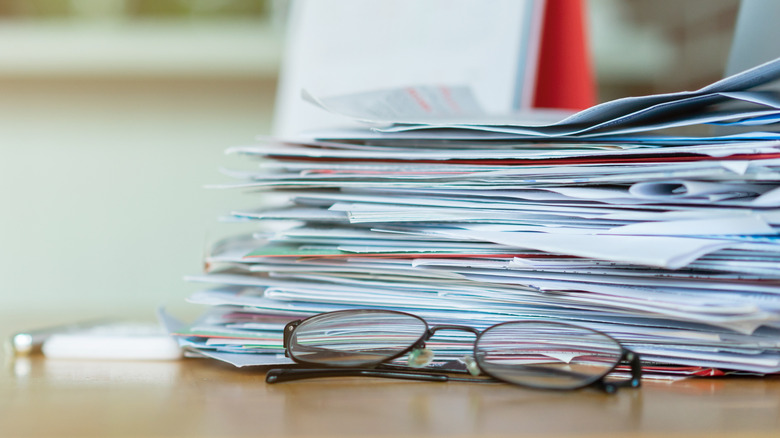 stack of messy mail on a kitchen counter