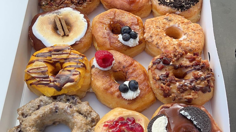 Assortment of creative donut flavors in box.