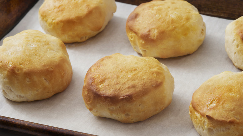 Golden brown biscuits on wooden cooking tray.