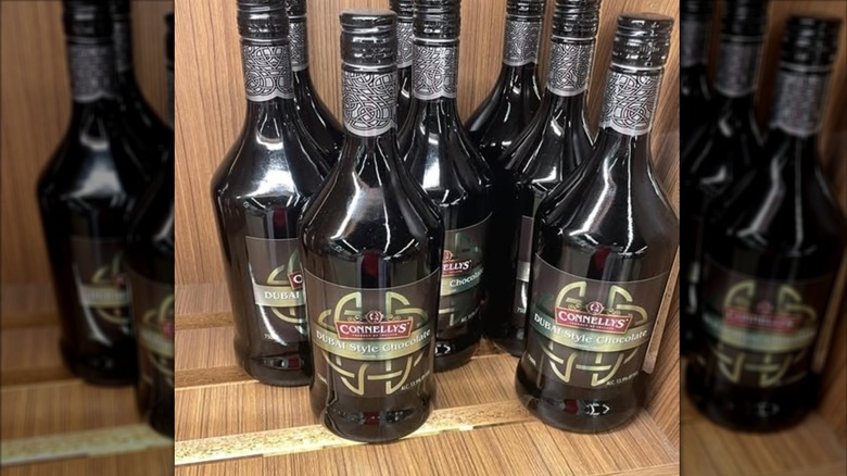 A mug of Irish coffee is on a wooden table.