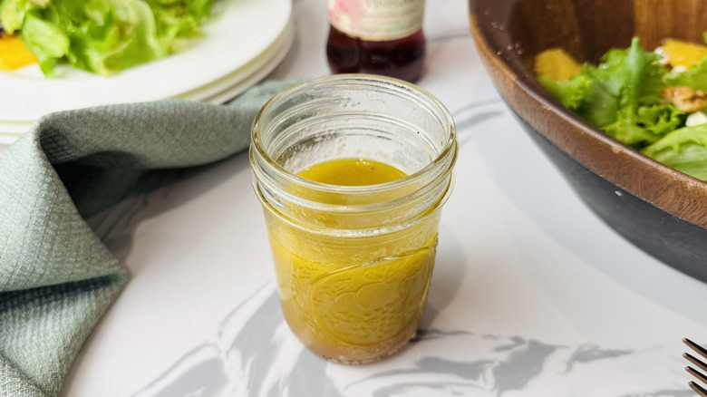Jar of red wine vinaigrette with salad