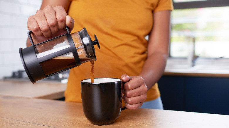 a pouring pouring a french press coffee