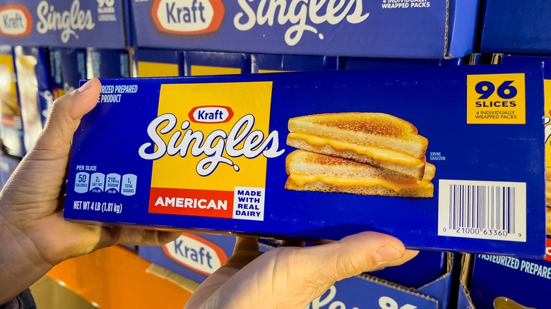 hands holding up a box of Kraft Singles cheese slices