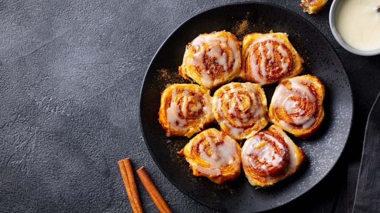 A plate of cinnamon rolls with icing