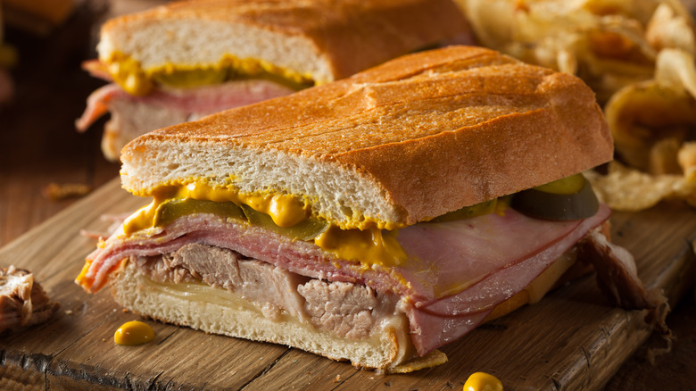 Halved cuban sandwich on wooden board