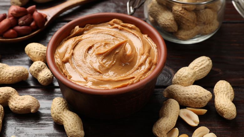 a bowl of peanut butter with raw peanuts