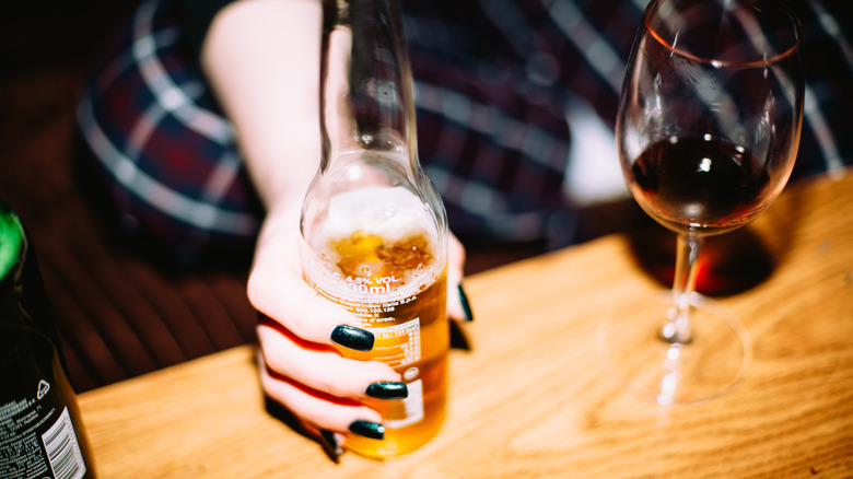 Person holding beer bottle