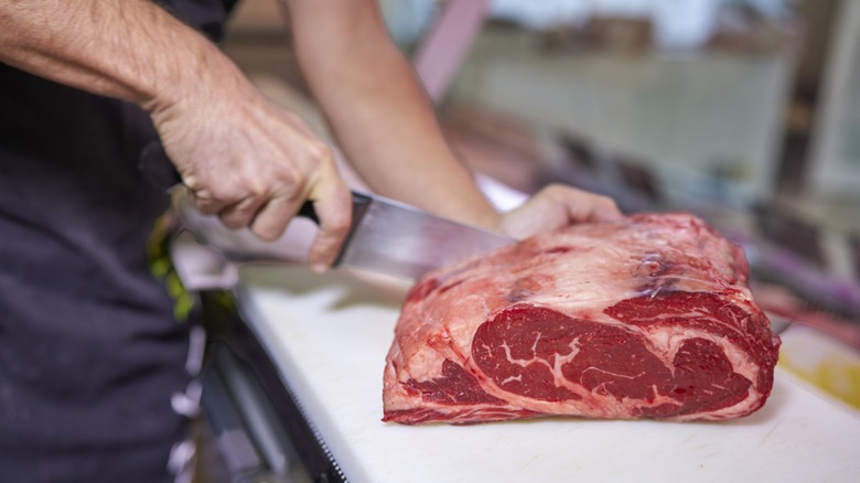 A butcher cutting steaks