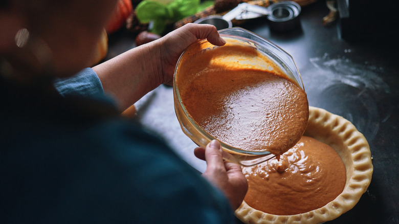 Pumpkin pie filling poured into crust