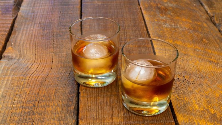 Two glasses of alcohol with sphere-shaped ice