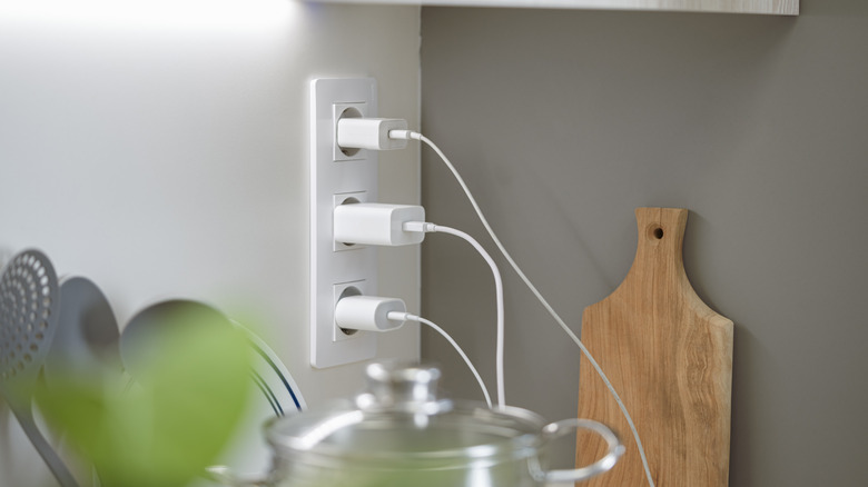 multiple chargers plugged into a kitchen socket
