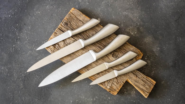 five knives on a cutting board