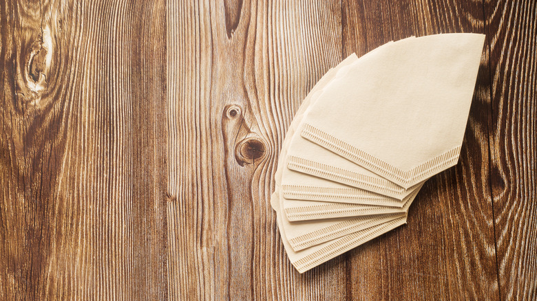 Coffee filters fanned out on a wooden background