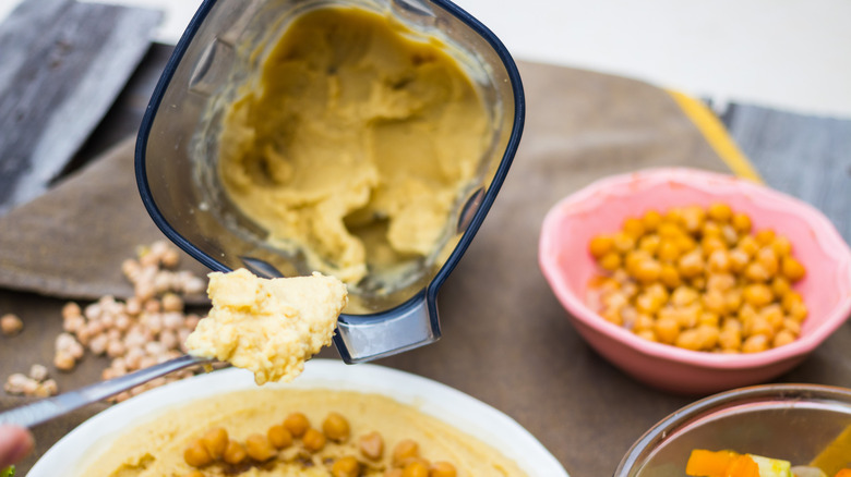 Sendok memegang hummus dari blender