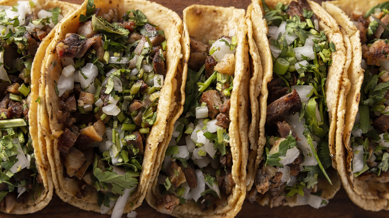 A row of tacos lined up on a table