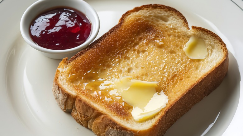 a slice of buttered toast served with jam