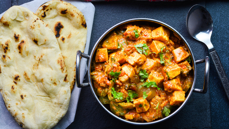 A paneer curry next to naan