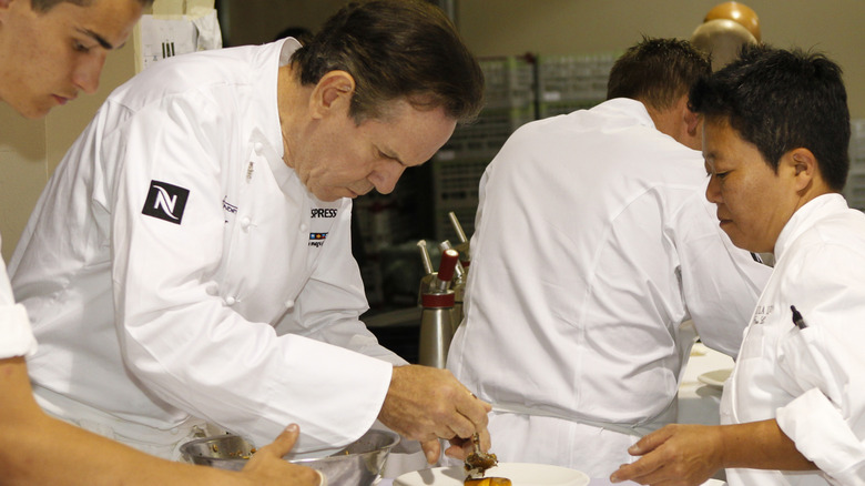 Thomas Keller plating a dish with other chefs