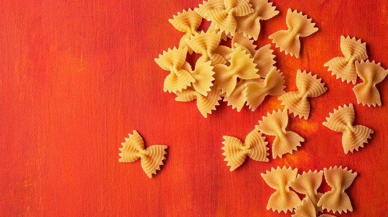 bronze-cut farfalle pasta on red background