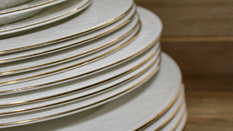 stack of white plates with gold trim