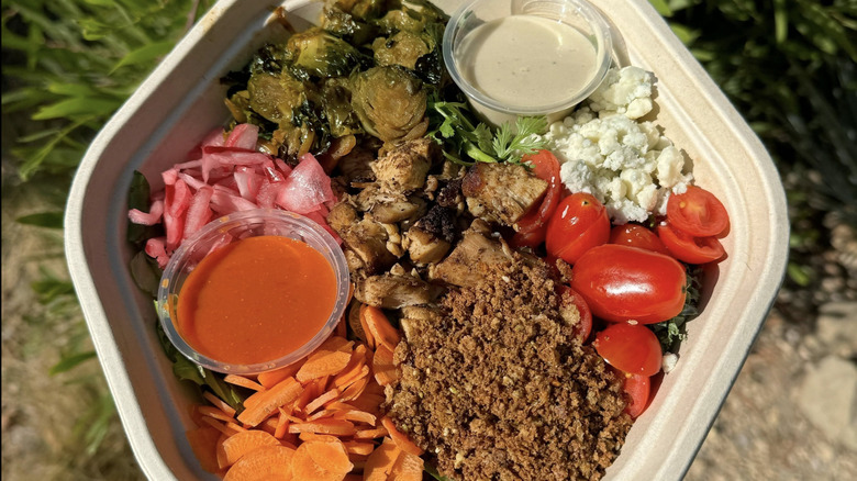 A Sweetgreen bowl features chicken, brussels sprouts, tomatoes, and more.
