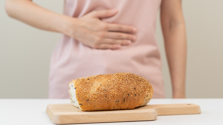 woman holding stomach with bread