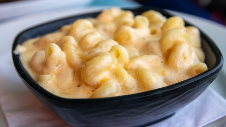 Mac and cheese in a black bowl on a white napkin