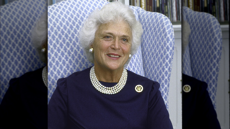 Barbara Bush smiling, wearing a blue dress and pearls
