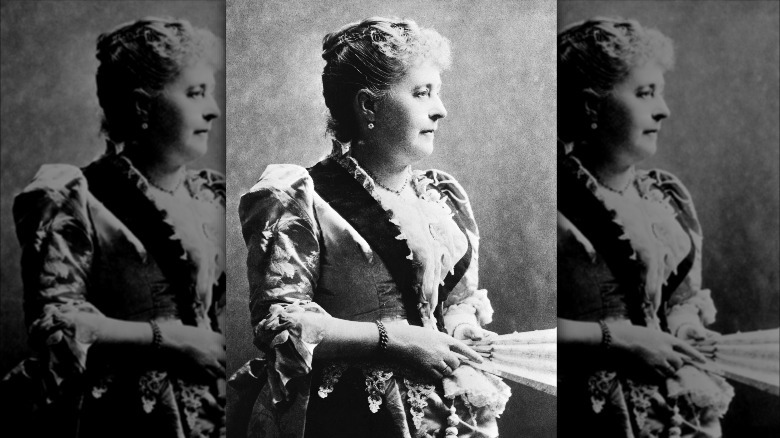 Caroline Harrison wearing a dress and holding a fan