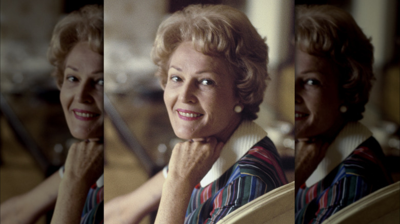 Pat Nixon smiling with a hand under her chin